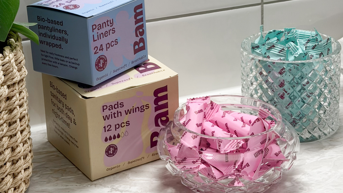 BAM Panty Liners 24-pack och Pads with wings 12-pack på marmorbänk i badrum – individuellt inpackade trosskydd och bindor i ekologisk bambu, biobaserade och andningsbara.